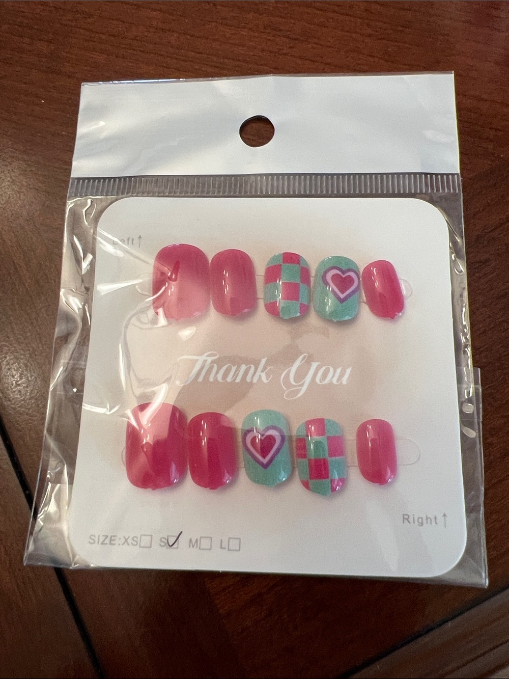 Pink and blue press- on nails featured a vibrant checkered board pattern Heart